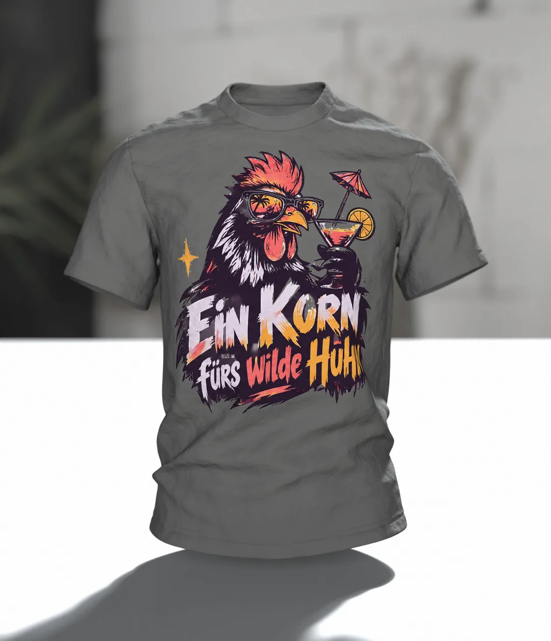 Ein Korn fürs wilde Huhn T-Shirt: Party-Hahn mit Sonnenbrille und Cocktail, Pinselschrift, Rückenprint, Im Raum