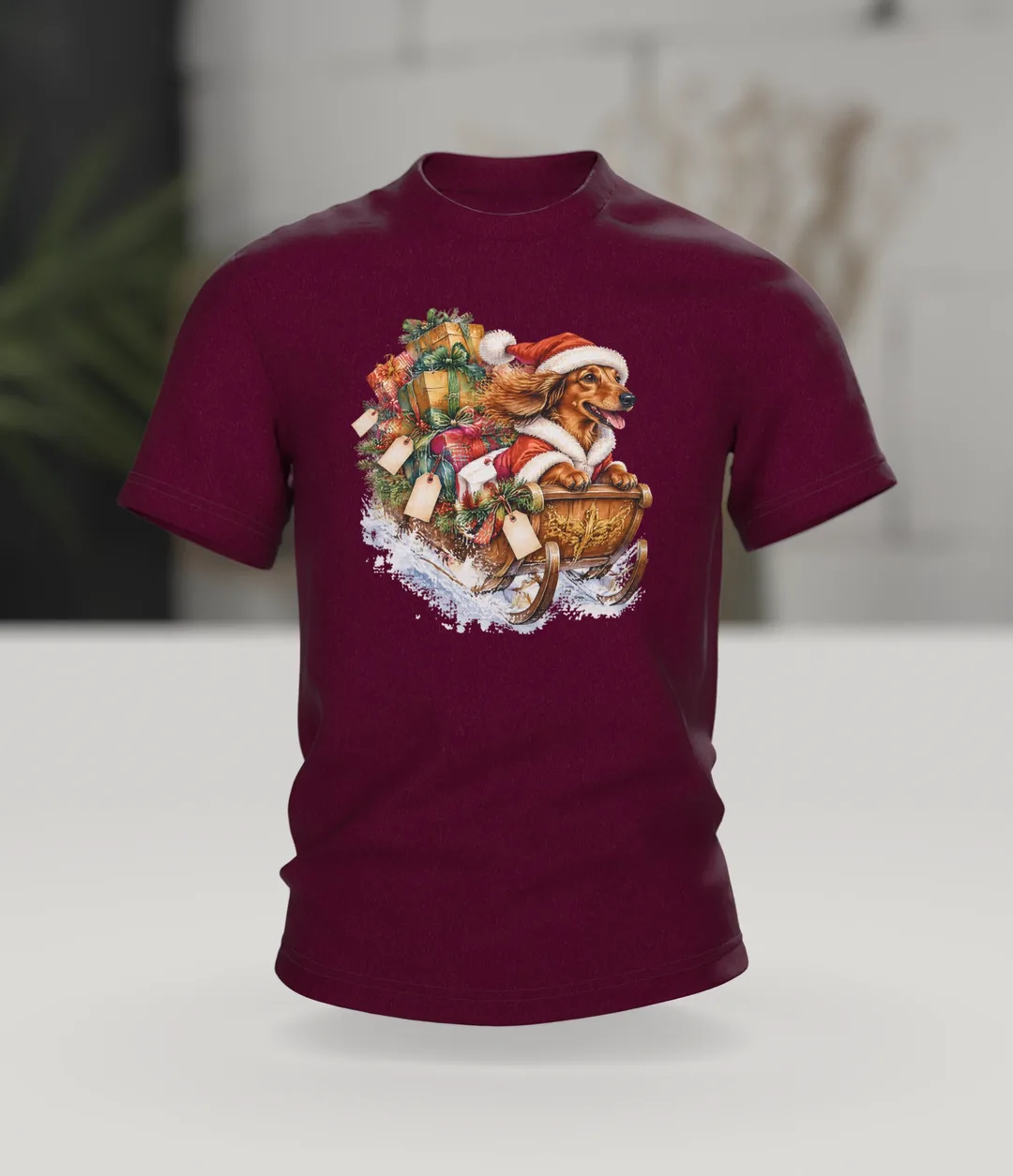 Weihnachtshund T-Shirt: Dackel als Weihnachtsmann im Geschenkeschlitten, Aquarell mit Blockhütte im Schnee auf dem Rücken, Im Raum
