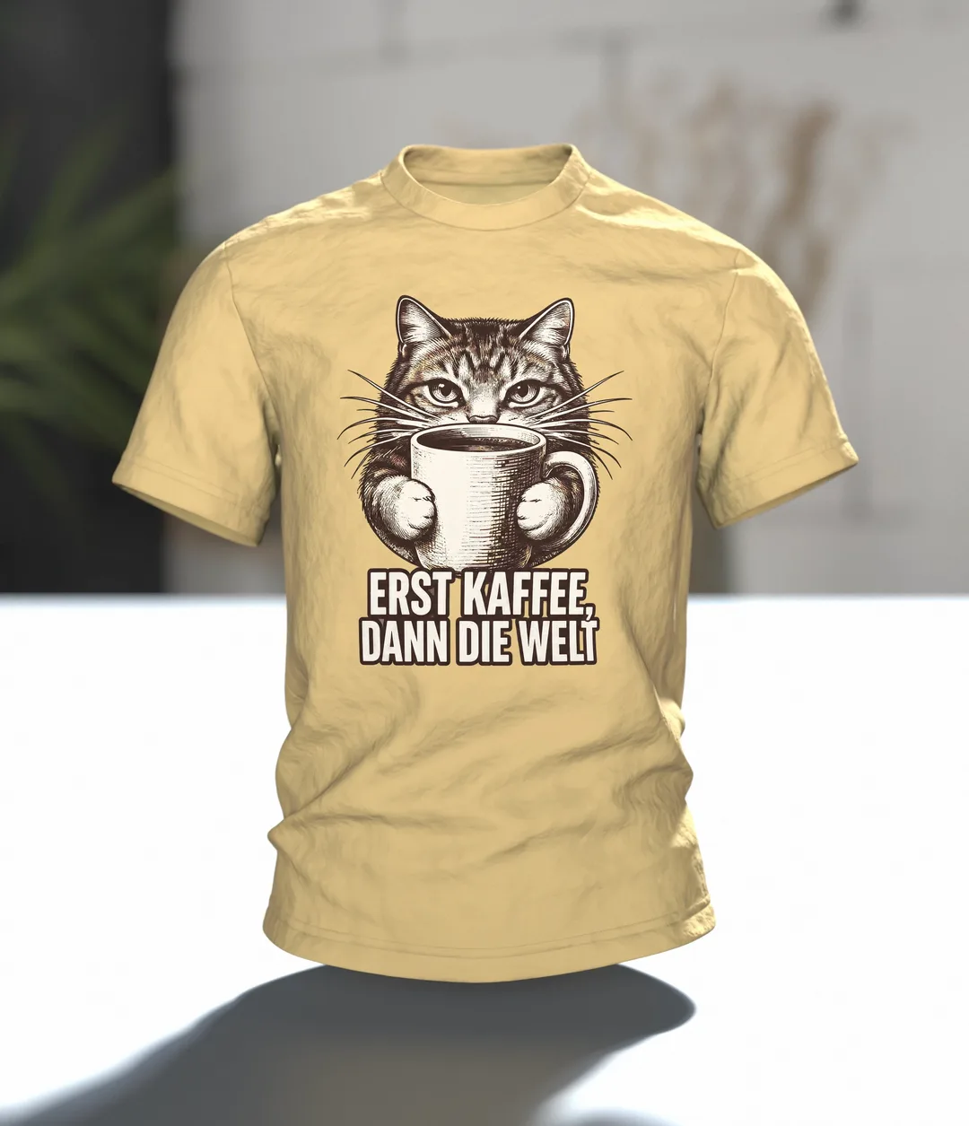 Katze umarmt Kaffeetasse T-Shirt: Erst Kaffee dann die Welt, Im Raum